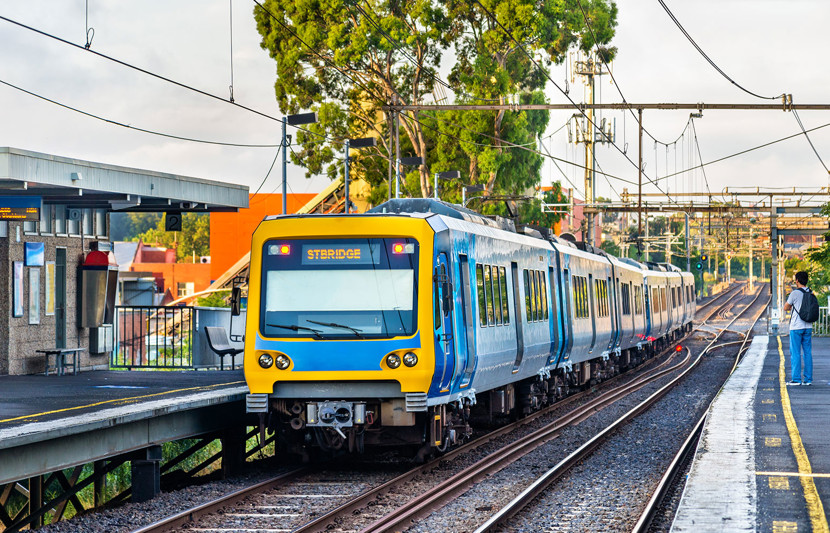 Blue and yellow commuter train pulling into a station in Victoria, Australia