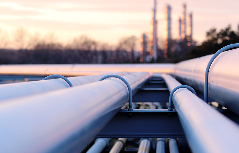 Steel long pipes running to factory during sunset