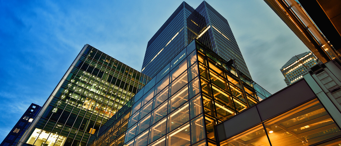 A view from the ground up of an office building lit up at night