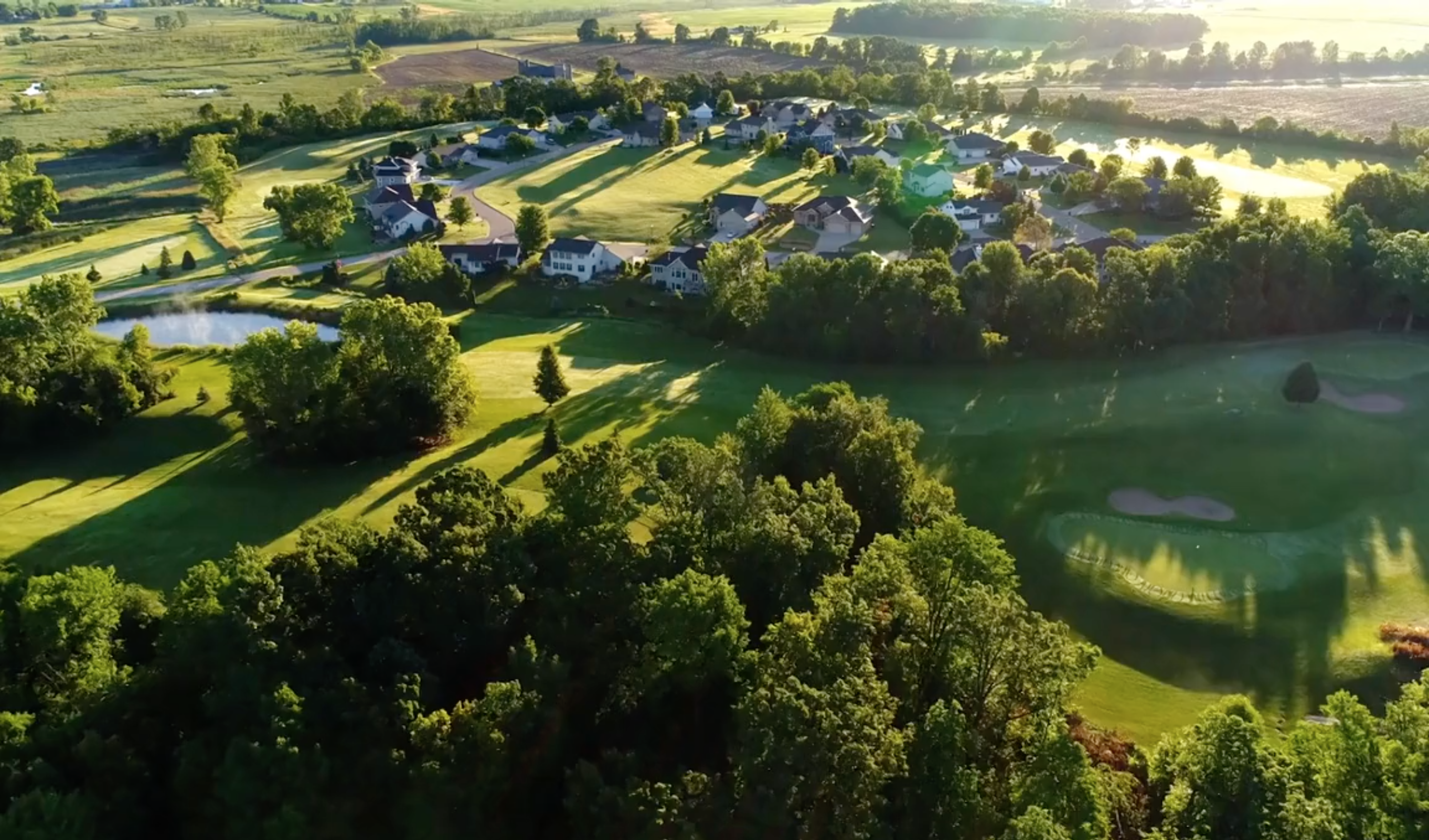 Aerial landscape with housing development surrounded by fields 