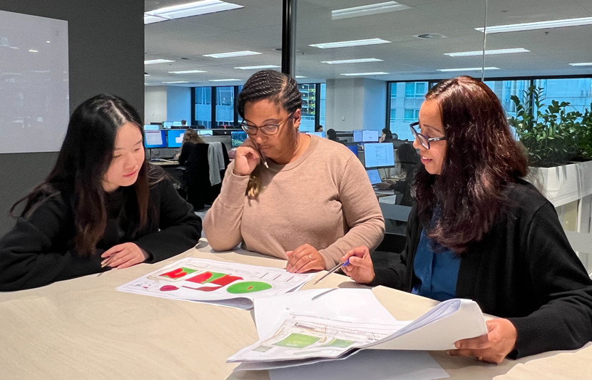 RPS' Cost Advisory team gather around a boardroom table reviewing data sets. 