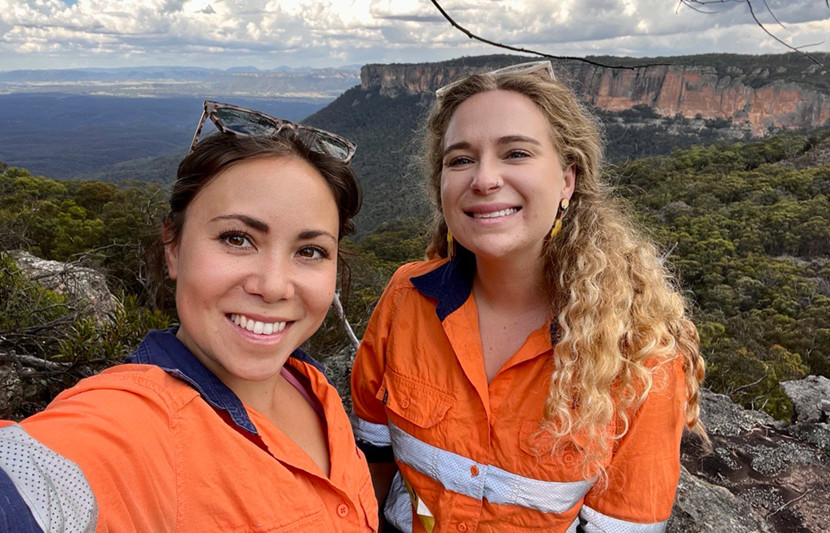 Ecologists Tara and Jess working onsite at Airly, both wearing orange high-vis PPE. 